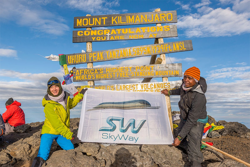 Installing the banner with SkyWay logo on the highest point in Africa — the peak of Mount Kilimanjaro